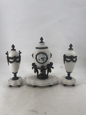 three vases and a clock sitting on a table