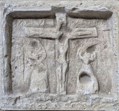 a stone relief of a man and a woman on a cross