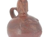a brown vase with a cat sitting on top of it