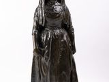statue d'une femme vêtue d'une longue robe et portant un chapeau sur la tête