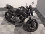 une moto noire garée sur un sol à damier