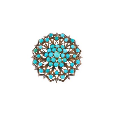 un gros plan d'une broche en pierre turquoise sur fond blanc