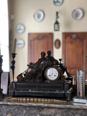 une horloge posée sur un plan de travail en marbre