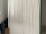 une armoire blanche dans une pièce au sol carrelé de blanc