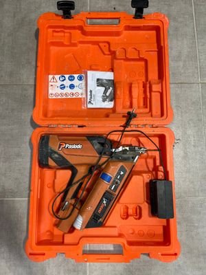 une boîte à outils orange contenant des outils, posée sur un sol carrelé