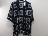 black and white patterned shirt hanging on a hanger in a room