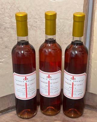 trois bouteilles de vin posées sur un tonneau en bois