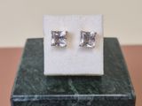 a close up of a pair of earrings sitting on top of a marble block