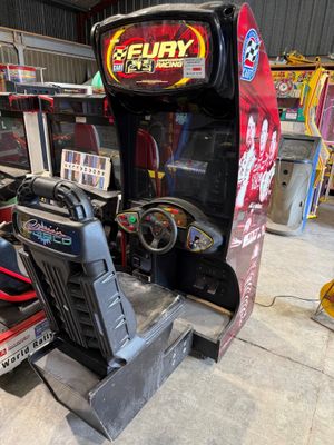 une photo d'une console de jeux installée dans un garage, avec un volant