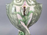 a green owl figurine with a flower in its mouth