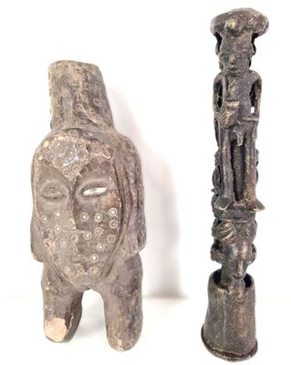 deux statues assises l'une à côté de l'autre sur une surface blanche