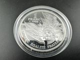 un gros plan d'une pièce de monnaie dans un récipient en plastique posé sur une table
