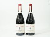 deux bouteilles de vin rouge posées l'une à côté de l'autre sur une surface blanche