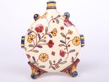 a white vase with a floral design on it