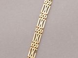 a close up of a gold bracelet on a gray surface