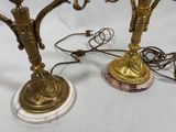 two candles that are sitting on a marble base