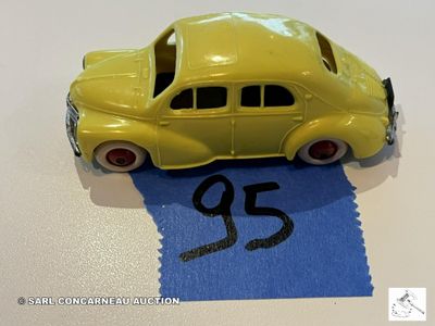 une petite voiture jaune posée sur une feuille de papier bleue