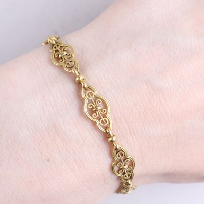an image of a woman ' s arm with a gold bracelet on it