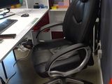 a black office chair sitting in front of a computer desk