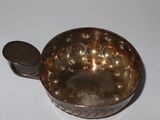 a small metal bowl with a lid on a table