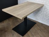 the table is made of wood and has a black metal base