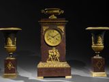 three vases and a clock sitting on a table