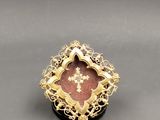 a close up of a gold ring with a cross on it