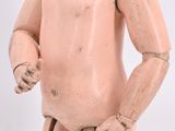 an old wooden doll is standing with his hands on his hips
