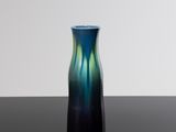 un vase bleu et vert posé sur une table noire