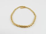 un bracelet en or avec un motif de tresse sur fond blanc