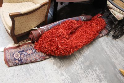 un tapis rouge posé par terre, à côté d'une chaise et d'une table