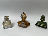 trois petites bouteilles en verre posées les unes à côté des autres sur une surface blanche