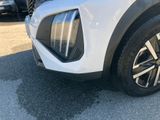 the front end of a white suv parked in a parking lot