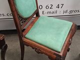 an old chair with a green seat is sitting in front of a sign