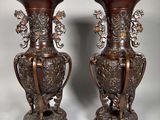 pair of antique bronze vases with flowers and leaves on them