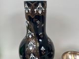 a black vase sitting next to other items on a table