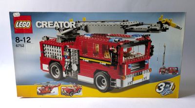 une boîte avec un camion de pompiers lego à l'intérieur