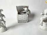 trois figurines représentant un homme et une femme assis sur une chaise