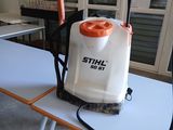une table blanche sur laquelle se trouvent une poignée orange et un pulvérisateur blanc
