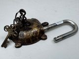 a small metal turtle with a key on top of it