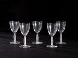quatre verres à vin vides sont alignés sur une table noire