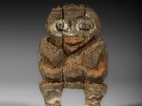 une image représentant une statue en bois d'un homme portant une capuche