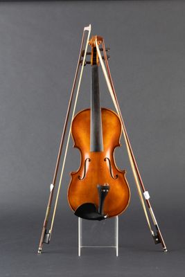 an old violin sitting on top of a stand on a gray surface