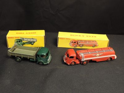 three toy trucks are sitting next to each other on a black surface