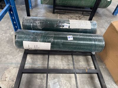 two rolls of green plastic mesh on a metal rack