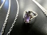 silver and amethorate ring with chain on a black surface