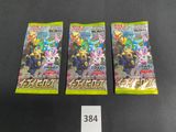three packs of pokemon trading cards sitting on a table