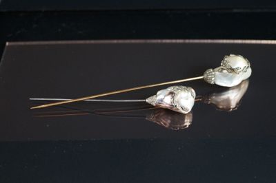 une paire de perles fixées à un bâtonnet posé sur une surface noire