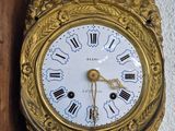 a gold clock with roman numerals on the face of it