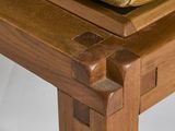 a close up of a wooden bench with a cushion on it